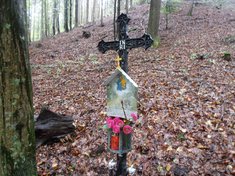 Bei dem Kreuz, das in dem Wald an die Opfer erinnert, brennt noch heute eine Kerze. (Foto: Keusch)